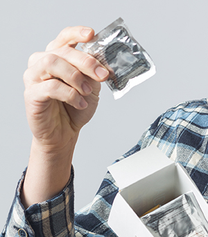Hombre sosteniendo una caja de preservativos.