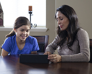 Mujer y adolescente mirando una tableta.