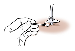 Primer plano de una mano con un hisopo de algodón que limpia debajo del anillo de soporte.