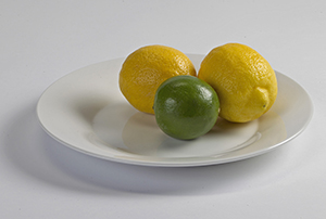 Dos limones y una lima sobre un plato.