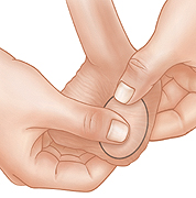 Primer plano de manos que revisan los testículos durante un autoexamen testicular.